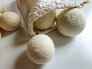 Closeup of sheep wool dryer balls for laundry in cream cotton bag