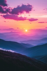 Fototapeta premium Breathtaking sunset over misty mountains with a vibrant pink and purple sky, creating a serene and magical atmosphere.