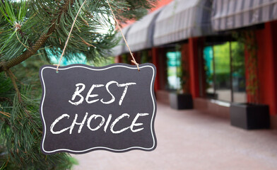 Best choice symbol. Blackboard with words Best choice. Beautiful background with shop and tree....