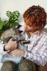 portrait of red-haired attractive young woman with grey big cat