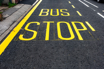 Bright Yellow Bus Stop Marking on Quiet City Street, Inviting Passengers to Wait Safely