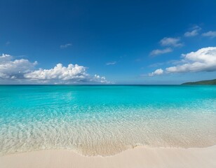 Obraz premium A serene beach scene with clear blue water lapping at a white sandy shore under a bright blue sky with fluffy clouds.