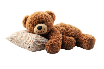 a teddy bear lying on a pillow. 