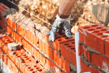 Crafting a Sturdy Wall With Vibrant Orange Bricks During a Sunny Day at the Construction Site
