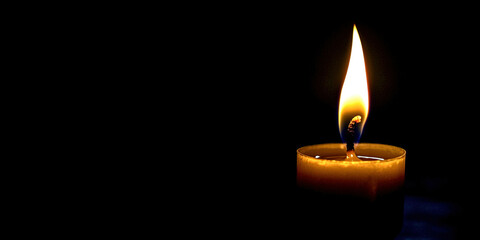 Burning candle on a black background