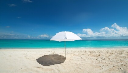 A single white umbrella stands on a sandy beach, casting a shadow on the pristine sand. The turquoise sea stretches out under a clear blue sky with fluffy white clouds.