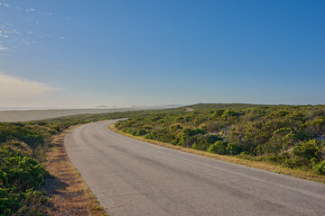 Sky, countryside and road with nature for trip, drive and travel on holiday in Kenya. Outdoor, adventure and tourism with sustainability, leisure and vacation with asphalt for break and journey