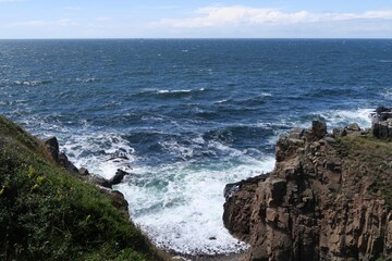 Wellen brechen an der Küste der Halbinsel Kullen. Gesehen vom Kullaberg in der Nähe des Leuchtturms Kullens fyr an einem sonnigen Sommertag.