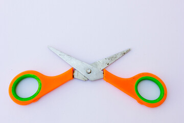 A small paper scissors with an orange handle.