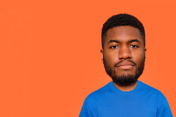 Unique Portrait Featuring Young Man With  Oversized Head Against an Orange Backdrop