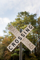 Railroad Crossing sign with trees in background