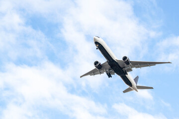 White passenger airplane flying in the sky amazing clouds in the background - Travel by air transport. High quality photo