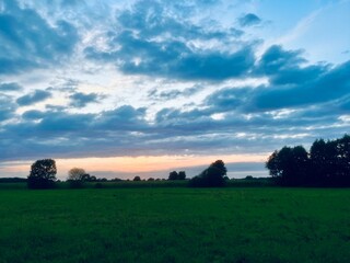 beautiful sunset sky in the green field, countryside