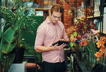 Business, flower shop and man with tablet, inventory and typing with internet, connection and nature. Professional, entrepreneur and employee with tech, digital app and check stock with plants