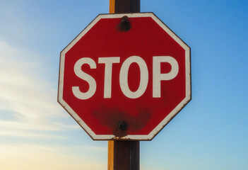 Obraz premium An old stop sign close-up against the blue sky