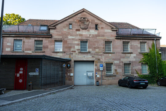 Das Bild zeigt die Vorderansicht eines Gebaeudes der Justizvollzugsanstalt N&uuml;rnberg. Das Geb&auml;ude ist aus Sandstein gebaut und mit vergitterten Fenstern versehen.