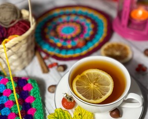 Cozy autumn photo with a cup of tea, flashlight, knitting, leaves and decor 