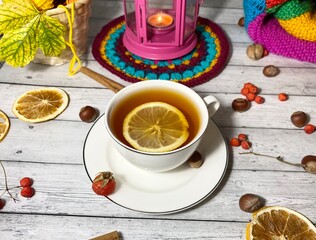 Cozy autumn photo with a cup of tea, flashlight, knitting, leaves and decor 