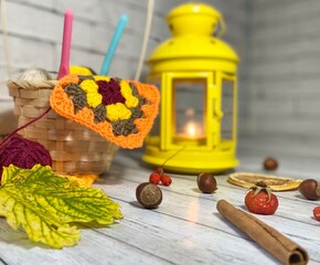 Cozy autumn photo with a cup of tea, flashlight, knitting, leaves and decor 