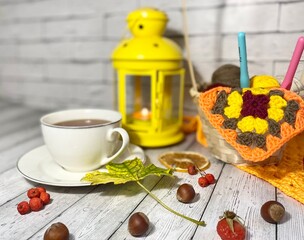 Cozy autumn photo with a cup of tea, flashlight, knitting, leaves and decor 