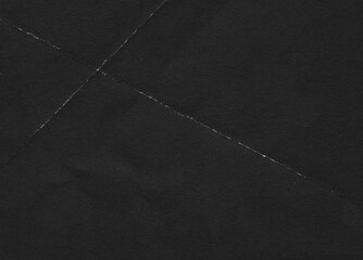 Fototapeta premium Folded paper black grunge texture with worn, rubbed and torn effect, old retro 90s texture for greeting cards, posters, web landings and other artworks