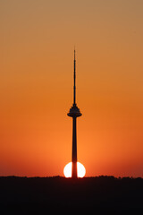 Obraz premium Silhouette of Tower at Sunset with Glowing Horizon