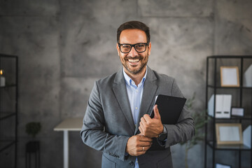 Portrait of confident businessman smile at office and hold clipboard