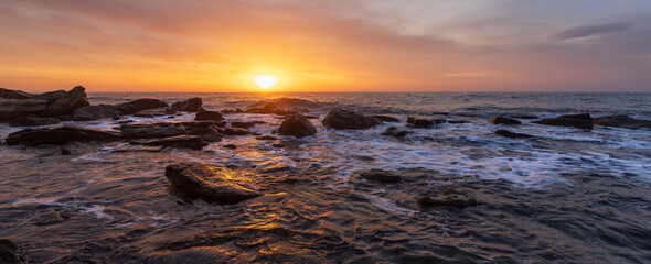 Obraz premium Amazing panoramic view. Sunset over the sea with rocky coast
