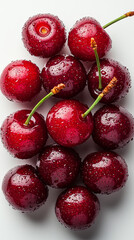 A cluster of ripe cherries with stems and water droplets.