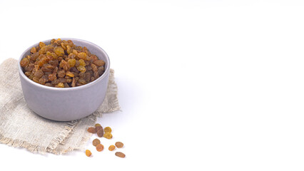 Yellow color golden raisins in ceramic bowl, dried raisins natal in gray bowl, yellow raisins on white background, kismis in ceramic bowl