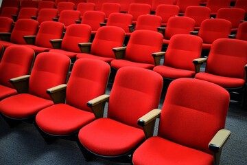 Fototapeta premium Vibrant red row chairs enhance the ambiance of the theater space for an engaging experience