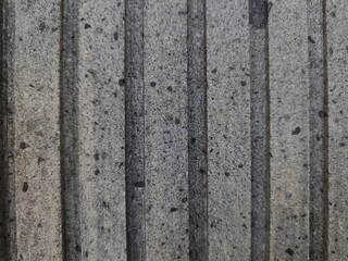 The texture of the cement wall forms a vertical line