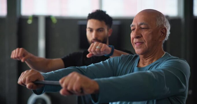 Senior man, resistance band and exercise with coach in gym for strength, support and joint health. Elderly person, stretching and personal trainer with lesson for retirement, fitness or mobility help