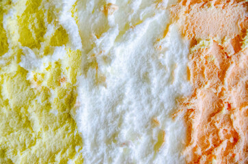 texture of yellow white and green ice cream like background, close up. Strawberry ice cream texture close up. Top view. Pink fruit ice cream background with small pieces of berries. High quality photo