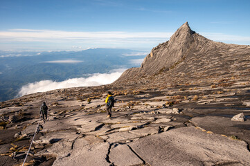 Rear view of tourist with an iconic peak named South Peak (3929 m) on Mt.Kinabalu, Malaysia.