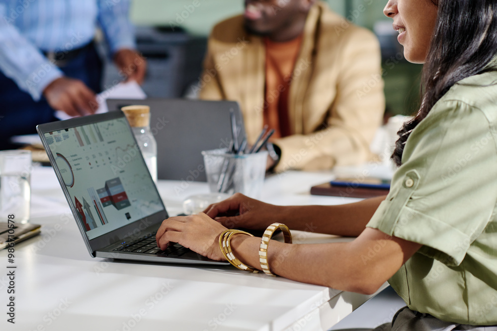 Aufkleber Man and woman collaborating in office analyzing business data on laptop screen with charts and graphs surrounding them. Visible documents and coffee cup on table enhancing professional atmosphere