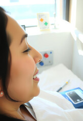 Fototapeta premium Woman laughing joyfully celebrating recovery hospital light background