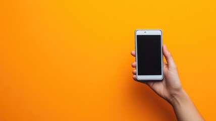 Hand holding smartphone against bright orange background
