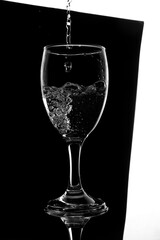 pouring water Empty wine glass isolated on black and white, splash water object in glass using mockup