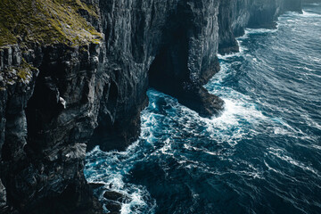 dramatic cliffs and crashing waves in dark blue ocean