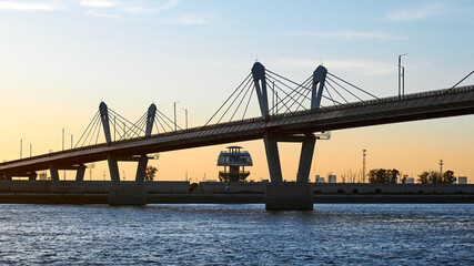 Cross-border bridge on the Amur River between Russia and China. View of the Chinese bank with a spherical observation tower on a summer evening at sunset.