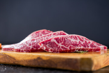 fresh raw beef sliced on wooden board close up shot