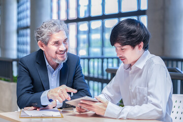 professor sitting and giving advice university student,young asian man using tablet computer conversation with advisor teacher