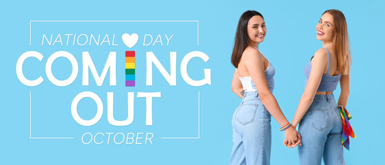 Beautiful young lesbian couple holding hands with LGBT flag in jeans pocket on blue background