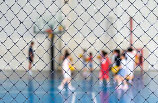blur basketball court by rope mesh net fence focus with many asian children or kid learning training shooting to playing basketball with coach and basketball hoop for healthy sport exercise background