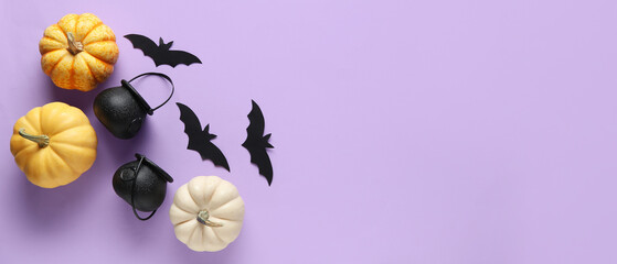 Paper bats, cauldrons and fresh pumpkins for Halloween party on lilac background with space for text