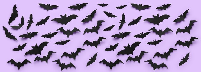 Many paper bats for Halloween party on lilac background