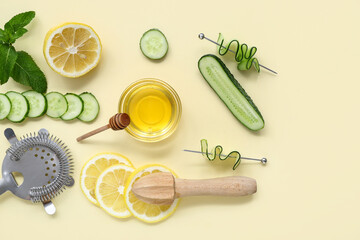 Fresh ingredients for cucumber mojito with strainer and juicer on yellow background