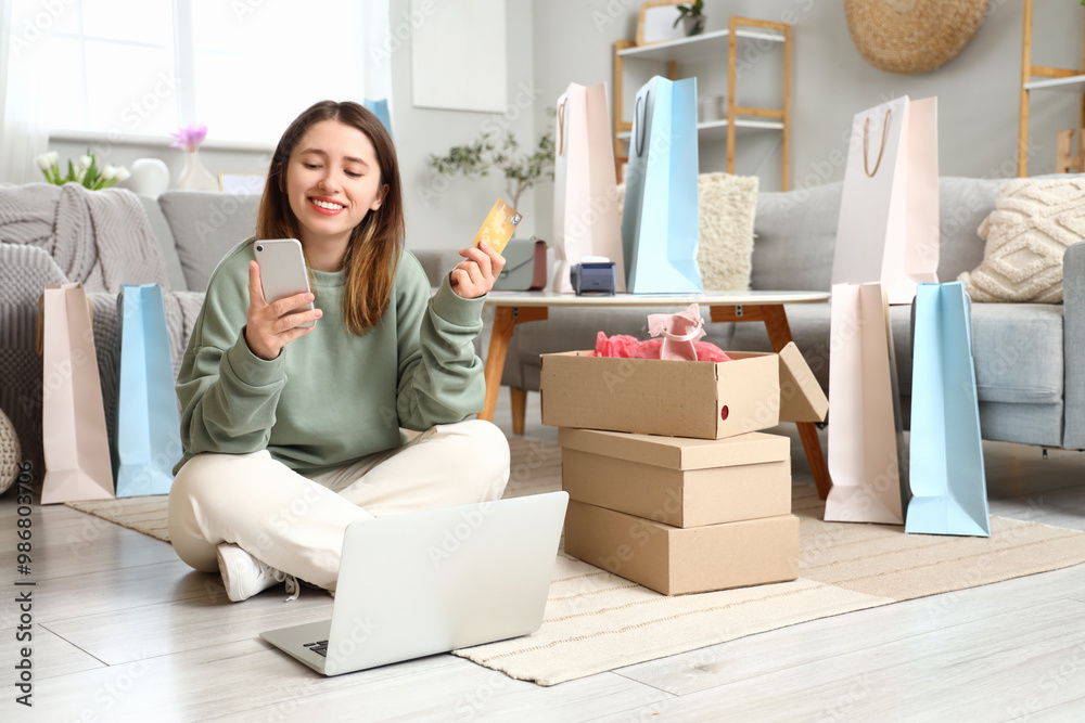 Canvas Prints Young woman with mobile phone and credit card shopping online at home