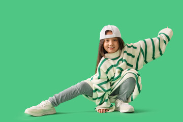 Cool little Asian girl in adult clothes on green background